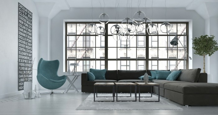Living room interior in a modern urban apartment with a grey upholstered corner lounge suite and blue tub chair against a large view window, 3d render