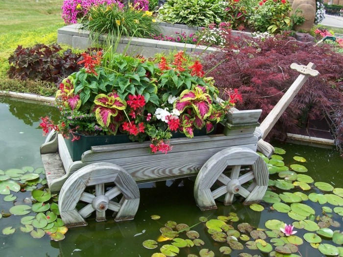 Schubkarre mit Blumen im Wasser