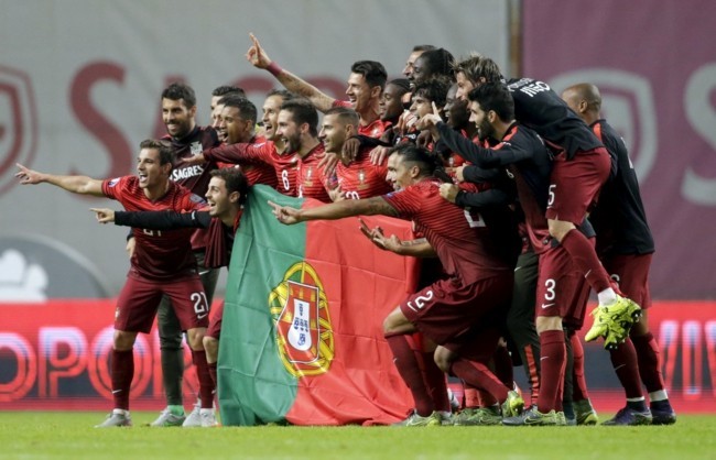 Portugal's team poses with the flag of Portugal at the end their Euro 2016 qualifying soccer match against Denmark at Municipal Stadium in Braga