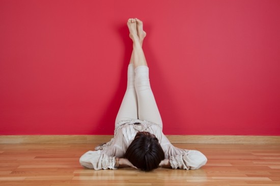 woman laying on the floor of her house next to a red wall