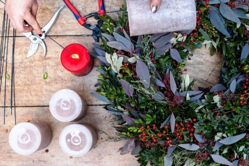 Prächtigen Adventskranz selber basteln mit rote Beeren, Tannen-, Lorbeer- und Buchsbaumzweigen kerzen vorbereiten