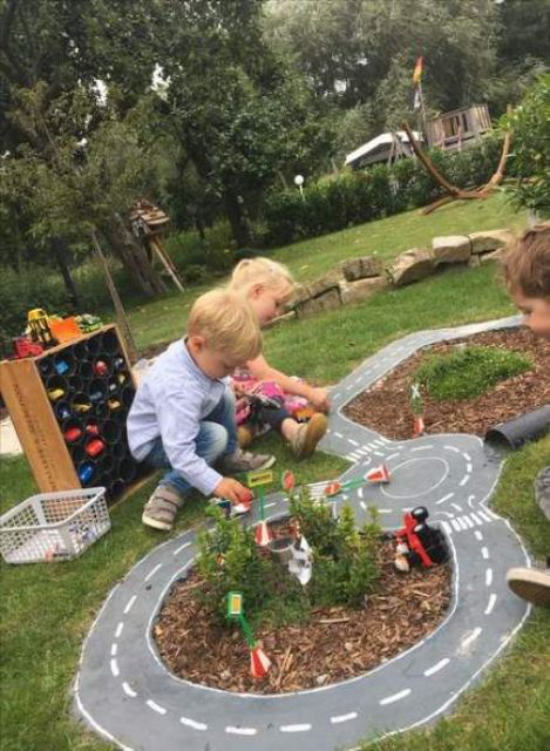 Kinderspielplätze im eigenen Garten drei Kleine spielen im Freien Fahrbahn Autorennen