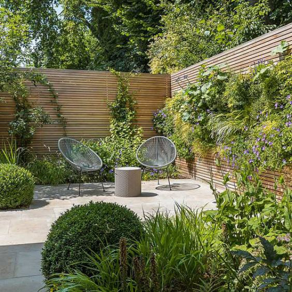Garten gestalten Platz für Ruhe Relax-Zone im Grünen zwei Metallstühle Holzwände