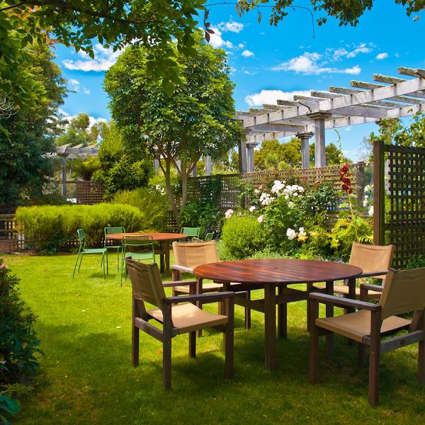 Garten gestalten moderne Gestaltung Esstisch Stühle im Freien grüner Rasen