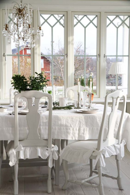 verglaste Veranda Glasveranda Esstisch Stühle alles weiß weiße Kerzen weißes Porzellan weiße Hüllen Tischdecke