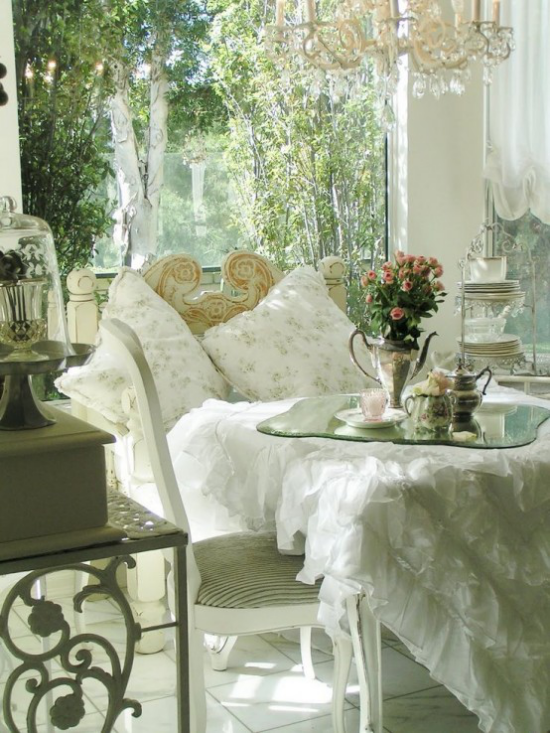 verglaste Veranda Glasveranda romantische Gestaltung weiße Tischdecke Rüschchen Service Tee trinken Vase mit Blumen Deko Kissen Kronleuchter