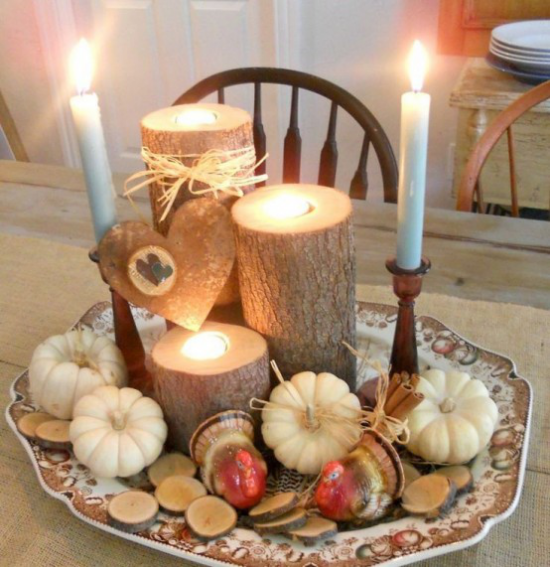 Duftkerzen Herbstdekoration Kerzen Kürbisse auf einem großen Teller auf dem Esstisch