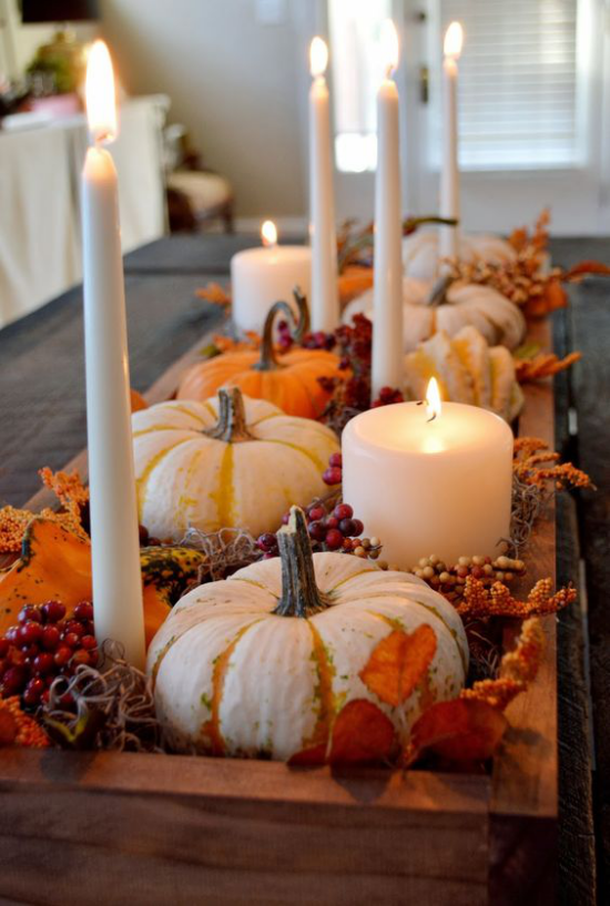 Herbstliche Tischdeko mit Kürbissen Kerzen bunte Herbstblätter Kerzen Beeren auf Tablett arrangiert