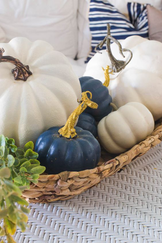 Herbstliche Tischdeko mit Kürbissen weiße und marineblaue Kürbisse im kleinen Flechtkorb