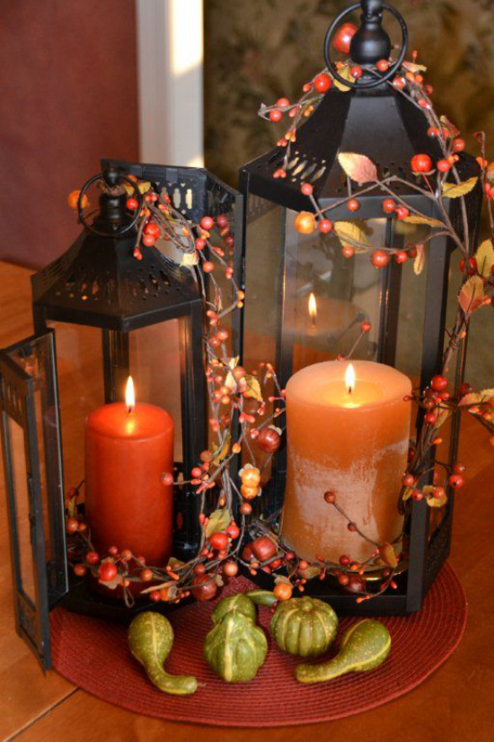 Laternen in der Herbstdeko zwei Laternen unterschiedliche Größe zwei Kerzen rote Waldbeeren kleine grüne Zierkürbisse