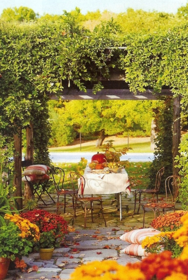 Herbstdeko für draußen Esstisch im Freien unter einem grünen Bogen schöne Farben romantische Atmosphäre