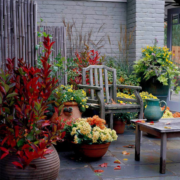 Herbstdeko für draußen rustikale Atmosphäre große Töpfe mit farbenfrohen Herbstblumen Herbstlaub Krug