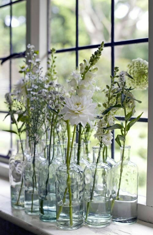 fensterbank deko mit pflanzen blumen arrangieren glasflaschen