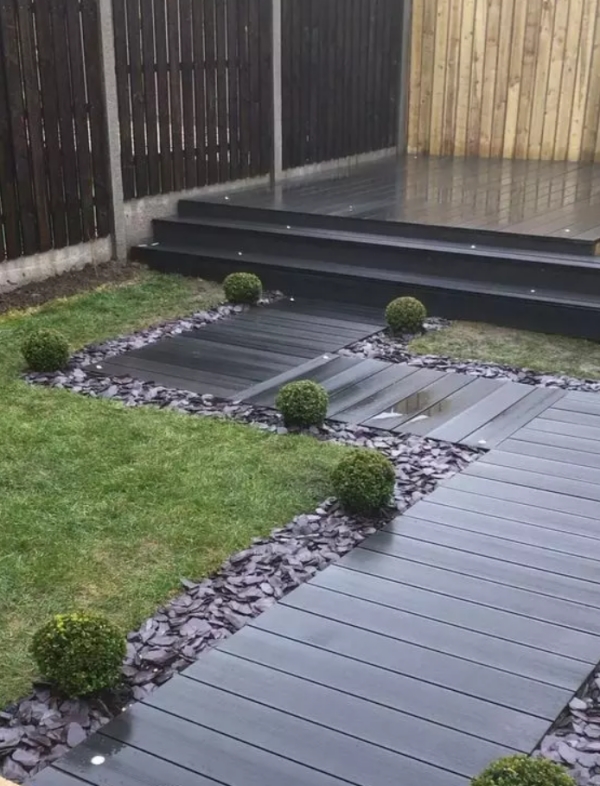 Gartenwege aus Holz dunkle Holzplatten fast schwarz Anthrazitfarbene Steine minimalistisches Gartendesign