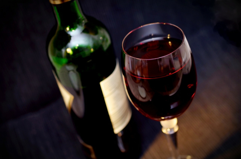 Glas und Flasche voller Rotwein 