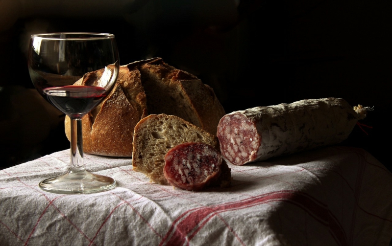 Rotwein mit Salami und Brot auf dem Tisch 