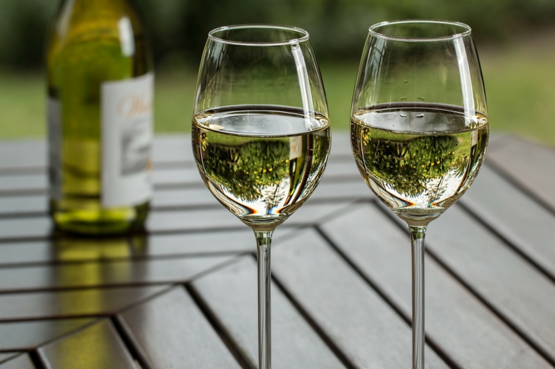 zwei Gläser voller Weißwein auf dem Tisch 